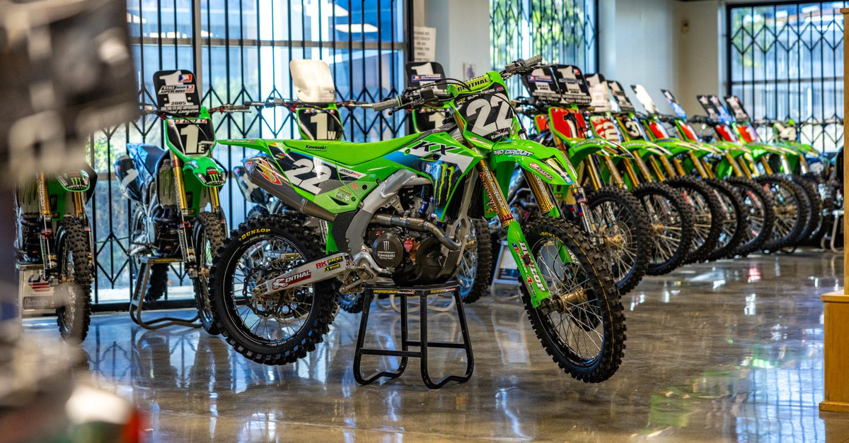 Monster Energy Pro Circuit Kawasaki race bikes at the team facility with Nate Thrasher's number 22 KX250 in front, 2027 team announcement